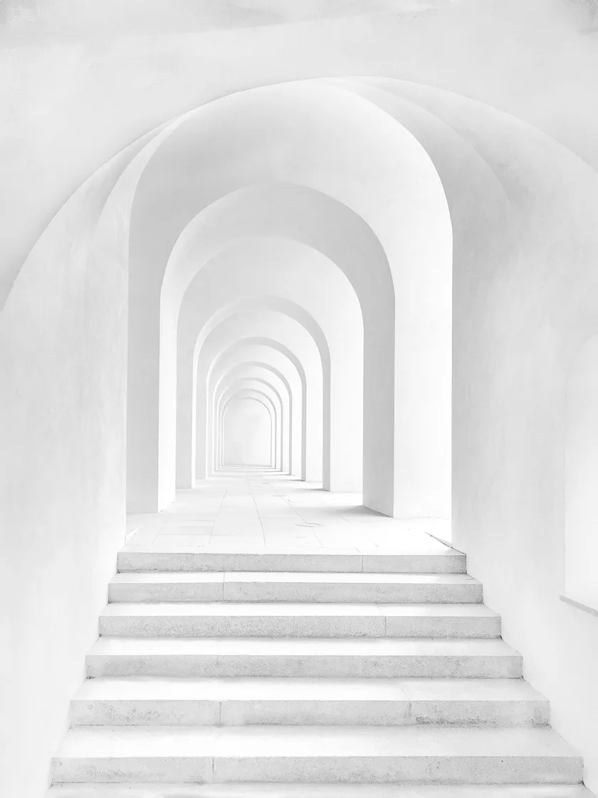 Enfilade d'arches blanches dans un couloir voûté